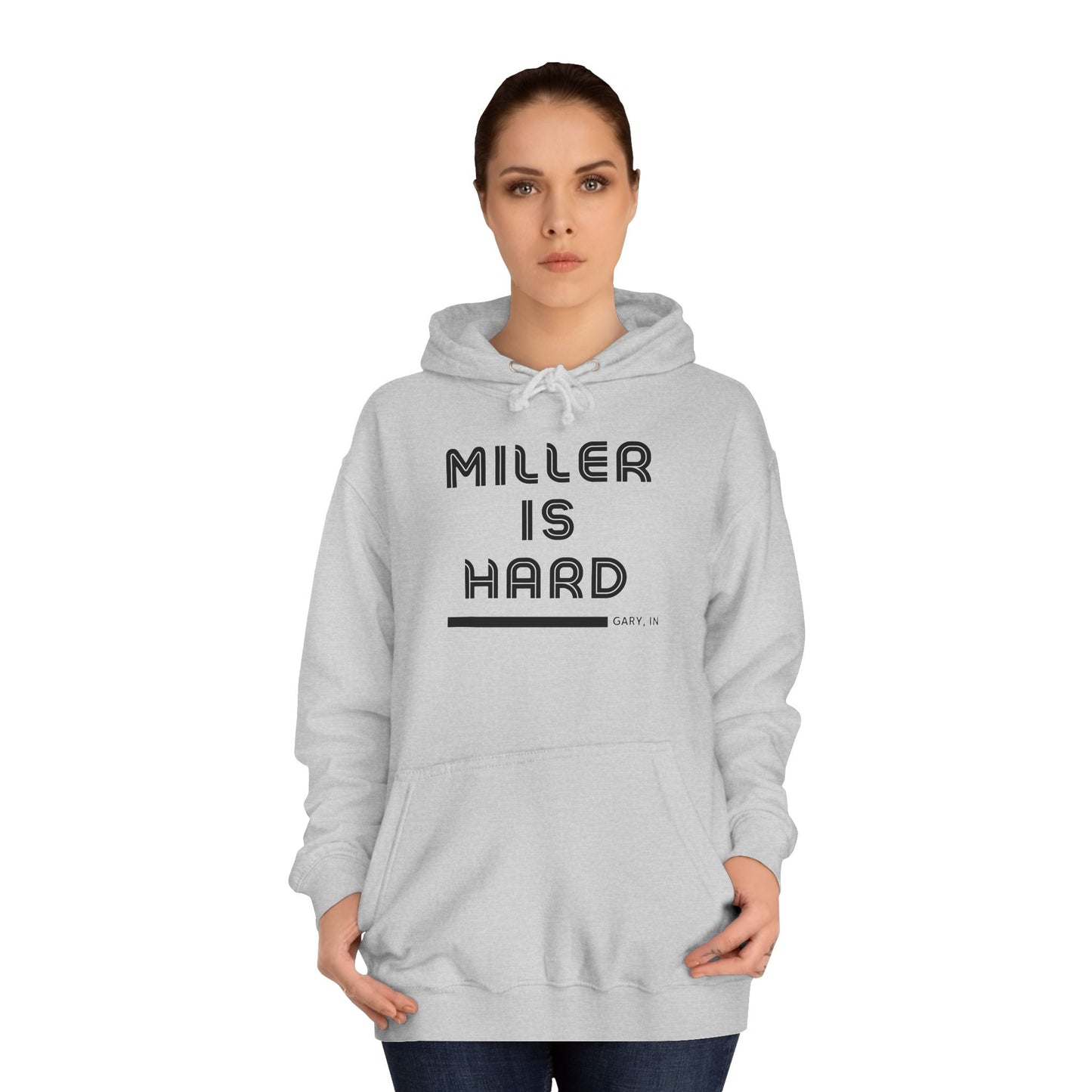 A light blue unisex college hoodie from Printify features the bold black text "MILLER IS HARD" on the front, with "GARY, IN." in smaller letters below. This hoodie is equipped with a front pocket and adjustable drawstrings, ideal for those who appreciate the Miller Beach style.
