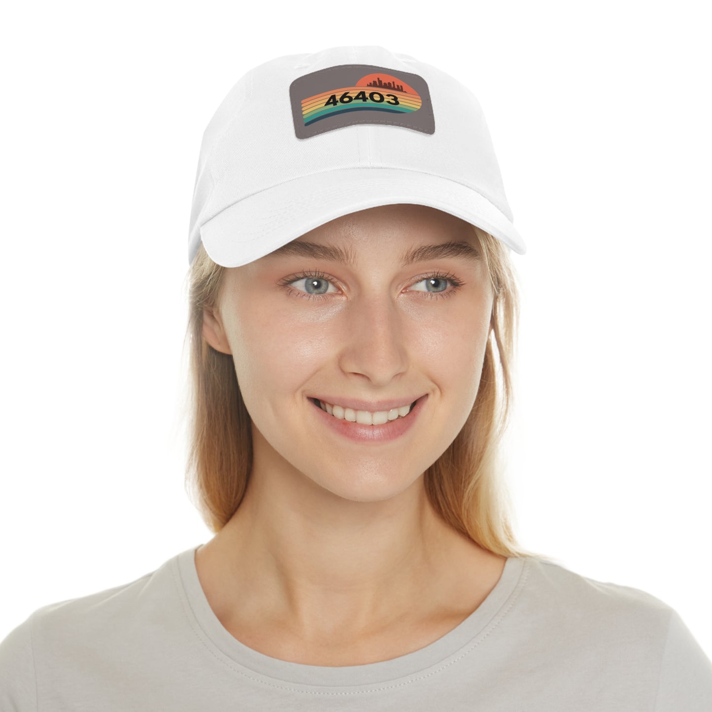 The Miller Beach Dad Hat from Printify, in a striking red and crafted from bio-washed chino twill, showcases a rectangular leather patch on the front. The patch features a stylized silhouette of a city skyline in black atop horizontal stripes in green, yellow, and orange, with the number "46403" prominently printed in bold black text.
