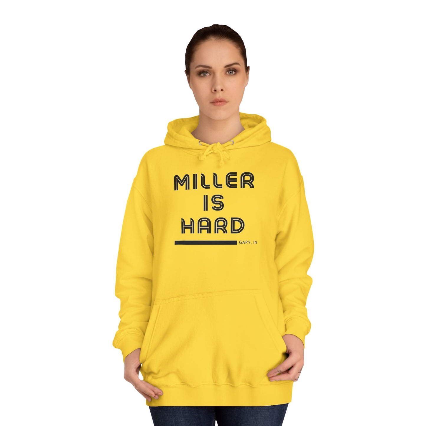 A light blue unisex college hoodie from Printify features the bold black text "MILLER IS HARD" on the front, with "GARY, IN." in smaller letters below. This hoodie is equipped with a front pocket and adjustable drawstrings, ideal for those who appreciate the Miller Beach style.