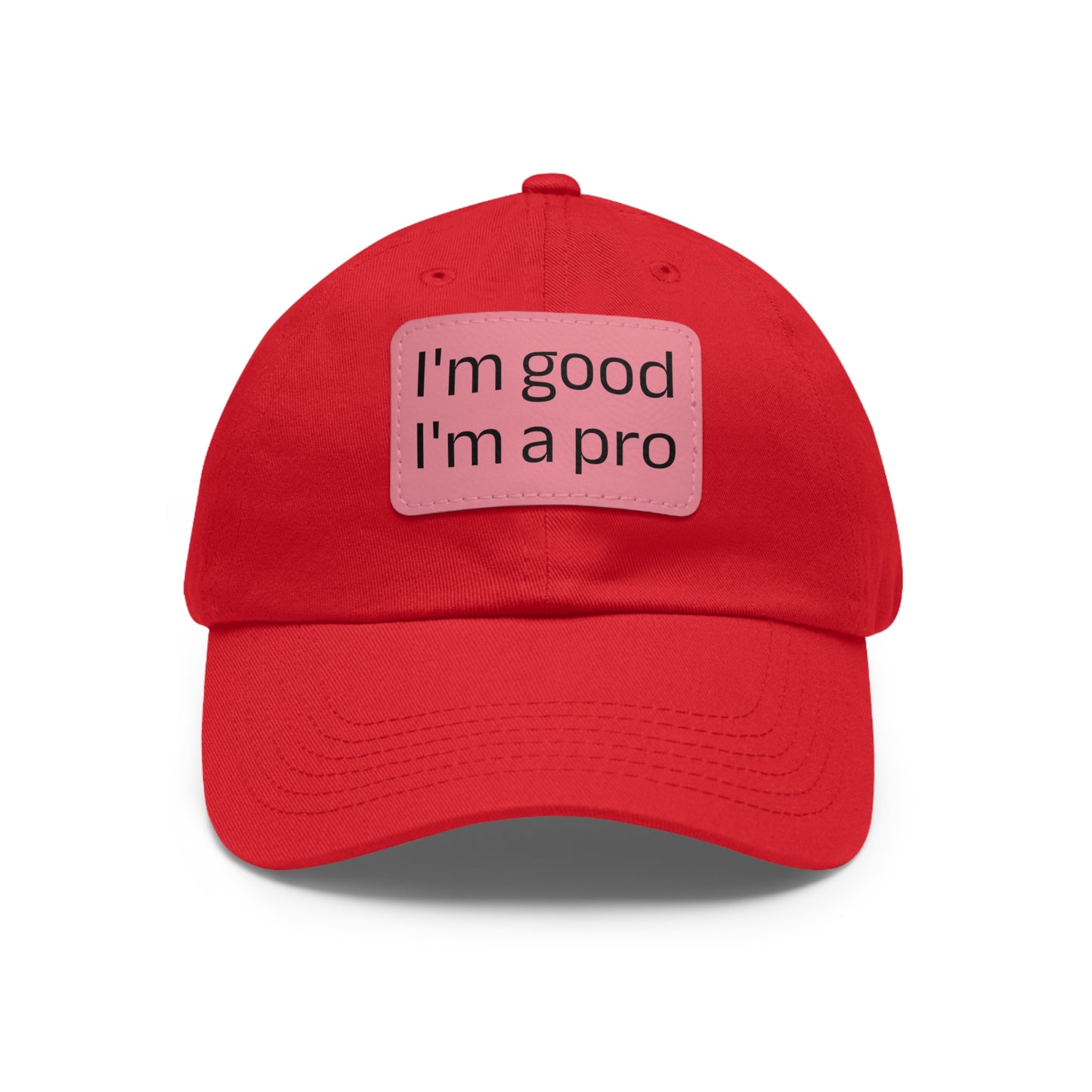 The Printify Dad Hat with Leather Patch (Rectangle) is a black, six-panel low-profile baseball cap made from bio-washed chino twill. This personalized Dad hat features a curved brim, visible stitching details, and a rectangular leather patch on the front that reads "I'm good I'm a pro" in grey text.