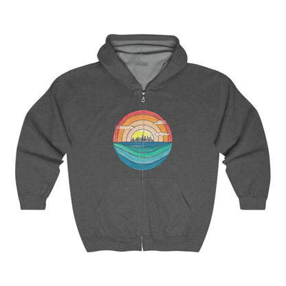 The Miller Beach Abstract - Full Zip Hooded Sweatshirt from Printify is gray and features a colorful circular graphic on the front. The graphic depicts a stylized sunset over a landscape with a blue horizon and water, transitioning to warm tones of an orange and yellow sky.