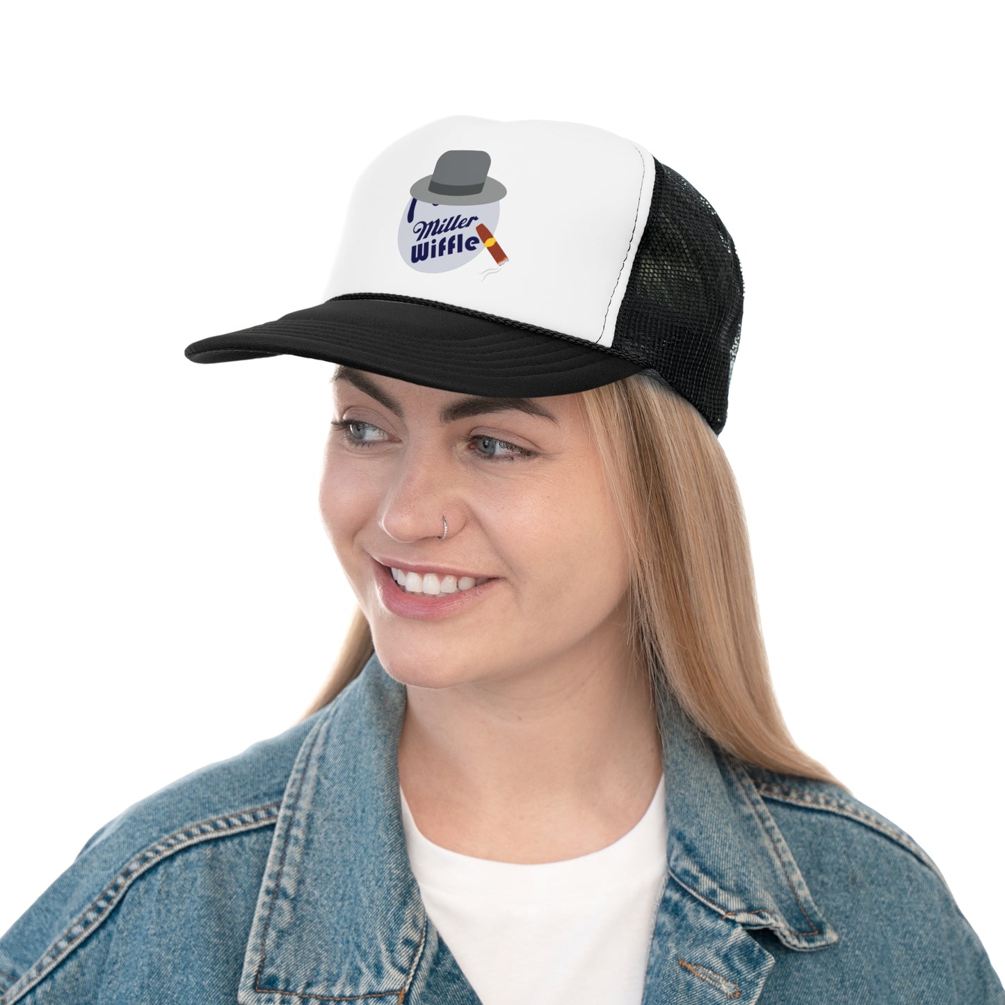 A smiling person with long hair and a nose ring wears the Miller Wiffel Ball ITYSL Driving Crooner Trucker Cap from Printify, which is white and pink and features a graphic of a hat, pipe, and "Miller Wiffle" text. The cap includes an adjustable snap closure for comfort. They are also wearing a blue denim jacket over a white shirt.