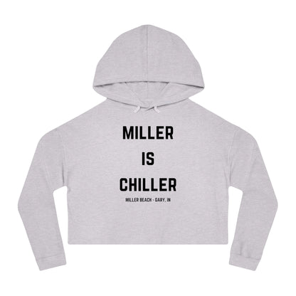 A white Women's Cropped Hooded Sweatshirt by Printify, featuring the phrase "MILLER IS CHILLER" printed in bold black letters on the front. Below the phrase, it says "MILLER BEACH • GARY, IN" in smaller black text. The SoCool Shirts hoodie includes a drawstring hood and long sleeves.