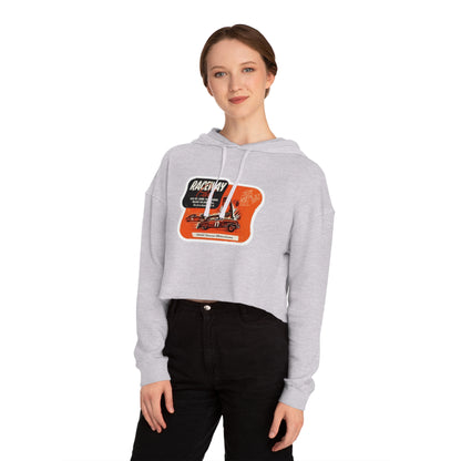 The Raceway Park - Blue Island, IL Women's Cropped Hooded Sweatshirt by Printify features an eye-catching camouflage pattern with a bold red and black "Raceway Park" graphic. Perfect for car enthusiasts, it is adorned with images of cars and text that celebrate a fictional race and hot rod theme, capturing the spirit of Blue Island racers.