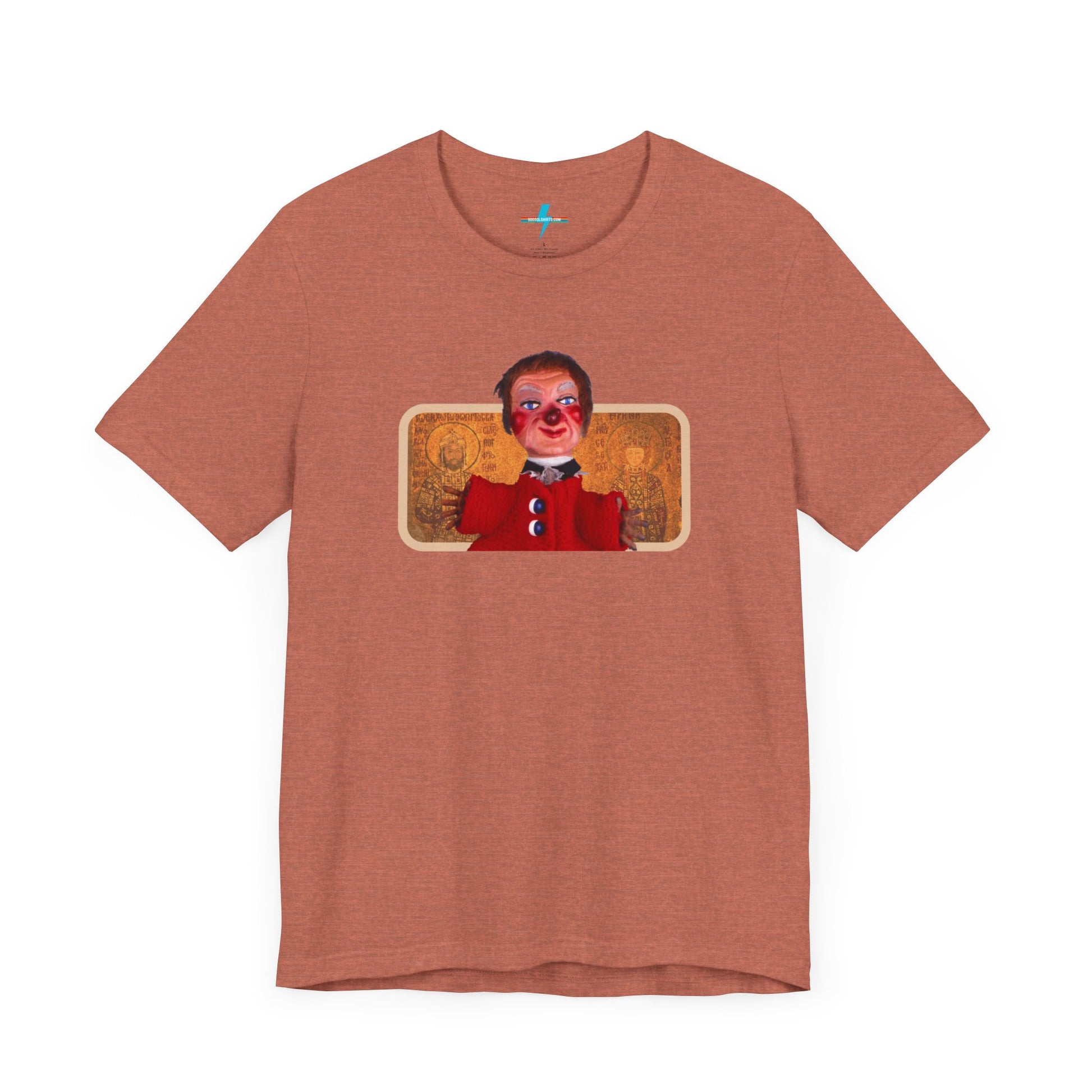 The rust-colored Printify Lady Elaine - Mr. Rogers Unisex Jersey Short Sleeve Tee features a detailed image of the Lady Elaine puppet, dressed in a red outfit with a painted face, set against an intricate artistic backdrop. The centrally positioned puppet and vivid colors create a striking contrast against the muted tone of the shirt, evoking nostalgic memories of Mr. Rogers' Neighborhood.