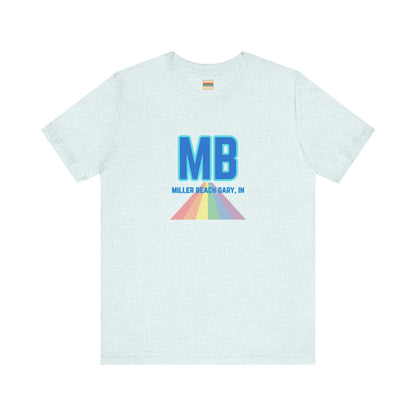 The Miller Beach Pride - Unisex Jersey Short Sleeve Tee by Printify is a white shirt made from 100% Airlume combed cotton. It showcases a design with large, bold blue letters "MB" at the top. Beneath it, the text "MILLER BEACH GARY, IN" is written in blue. A colorful, triangular rainbow graphic extends downward from the text, symbolizing Miller Beach pride.