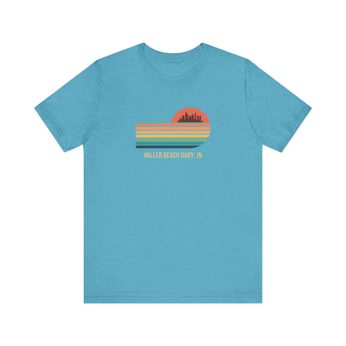 Introducing the Miller Beach Gary, IN Sunset Gradient - Unisex Jersey Short Sleeve Tee by Printify. This stylish blue T-shirt features a circular sunset graphic on the chest, showcasing a black city skyline silhouette against an orange-red sunset with horizontal stripes in green, yellow, and orange. Below the graphic reads "MILLER BEACH GARY, IN." Crafted from soft cotton for extra beachy charm.