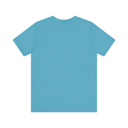 A light blue Printify "The Tinder Box 1980s" unisex jersey short sleeve tee featuring the "Tinder Box" logo in the center. The logo consists of a dark shield with the words "Tinder Box" in white text, with a small flame icon replacing the dot above the "i".