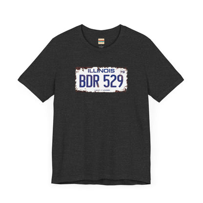 The Printify Blues Brothers BDR 529 License Plate Unisex Jersey Short Sleeve Tee showcases a vintage Illinois license plate graphic with "BDR 529" prominently displayed, as famously seen in the Blues Brothers film. The design includes "Illinois" and "Land of Lincoln" above and below the numbers, with a weathered, rustic look that enhances its retro appeal.