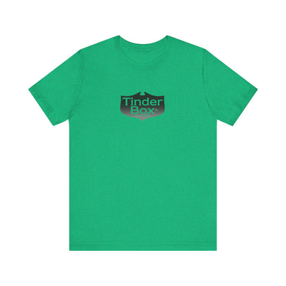 A light blue Printify "The Tinder Box 1980s" unisex jersey short sleeve tee featuring the "Tinder Box" logo in the center. The logo consists of a dark shield with the words "Tinder Box" in white text, with a small flame icon replacing the dot above the "i".