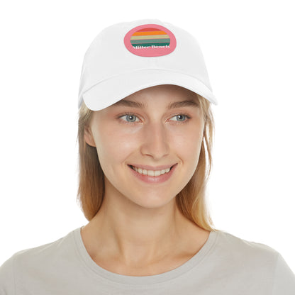 The Miller Beach Retro Sunset - Dad Hat with Leather Patch (Round) by Printify is a pink baseball cap crafted from bio-washed chino twill for added comfort. It features a PU leather patch adorned with horizontal stripes in red, orange, yellow, green, and blue. Below the stripes, "Miller Beach" is embroidered in white. An adjustable strap at the back ensures a perfect fit.