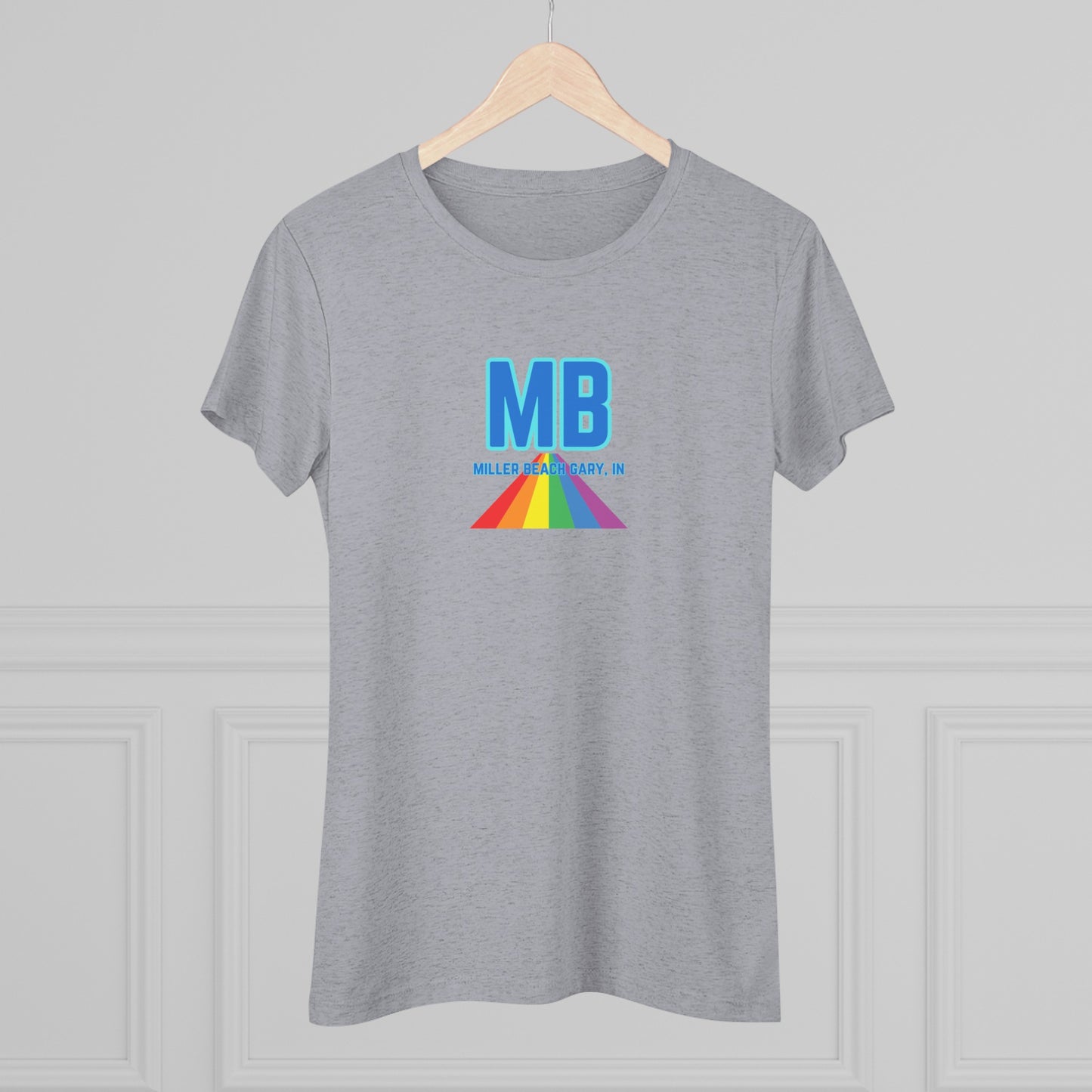 The Miller Beach Pride - Women's Triblend Tee by Printify is a dark gray, cozy t-shirt with a vintage look, featuring the text "MB" in large blue letters at the center. Below the letters, there is a rainbow-colored triangular design with "Millions & Binary, Inc." written in smaller text under the rainbow triangle.