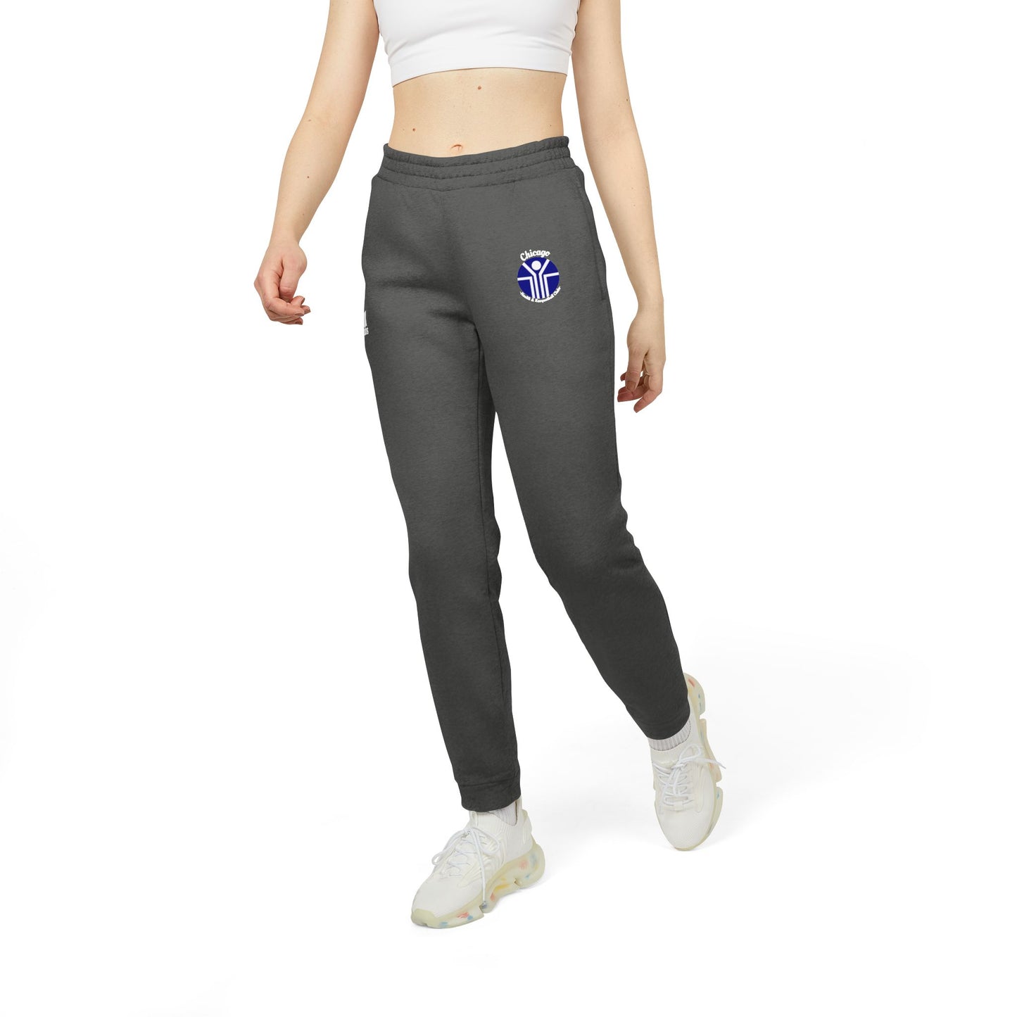 Gray Adidas unisex fleece joggers from Printify, showcasing the classic Chicago Health Clubs - Bally's 1980s logo on the left thigh and a blue and white emblem on the right. Crafted from sustainable BCI cotton, these joggers feature an elastic waistband and cuffs for maximum comfort.