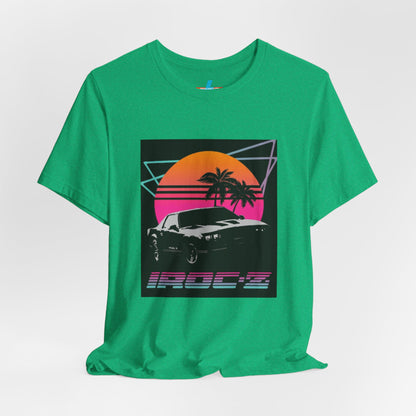 A Chevrolet Camaro iRoc Z Z28 T-Shirt 1980's by Printify, featuring a retro design with a black car, palm trees, and a sun setting in the background. The design includes geometric lines in neon colors and the text "IROC-Z" at the bottom, perfect for fans of the 1980s Chevy Camaro.