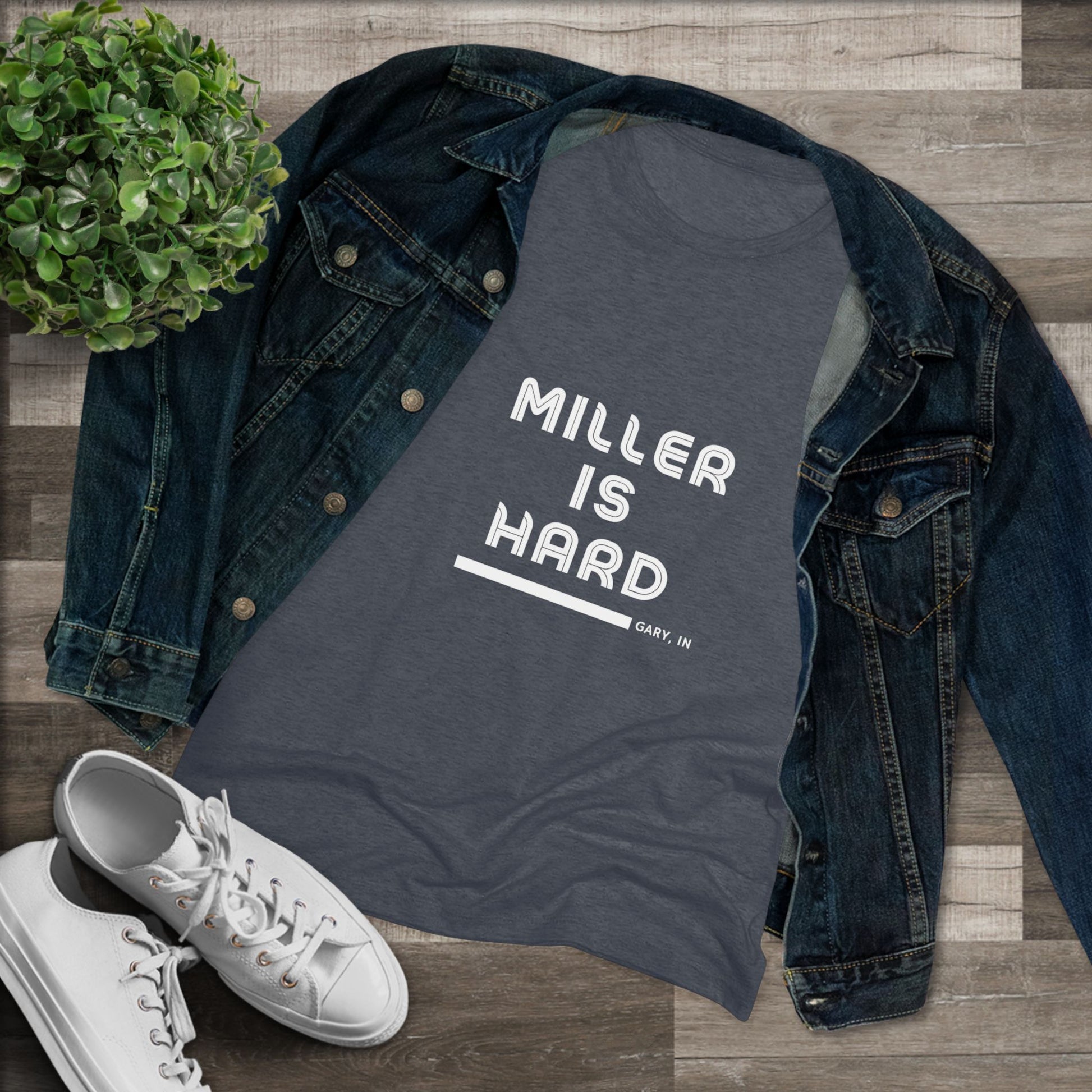 The Miller is Hard - Miller Beach Women's Triblend Tee by Printify features unique red coloring with white text that reads "MILLER IS HARD" and "GARY, IN" below, showcasing distinctive lettering spacing and alignment. Made from ultra-soft fabric, this shirt ensures a comfortable fit with a simple, casual design.