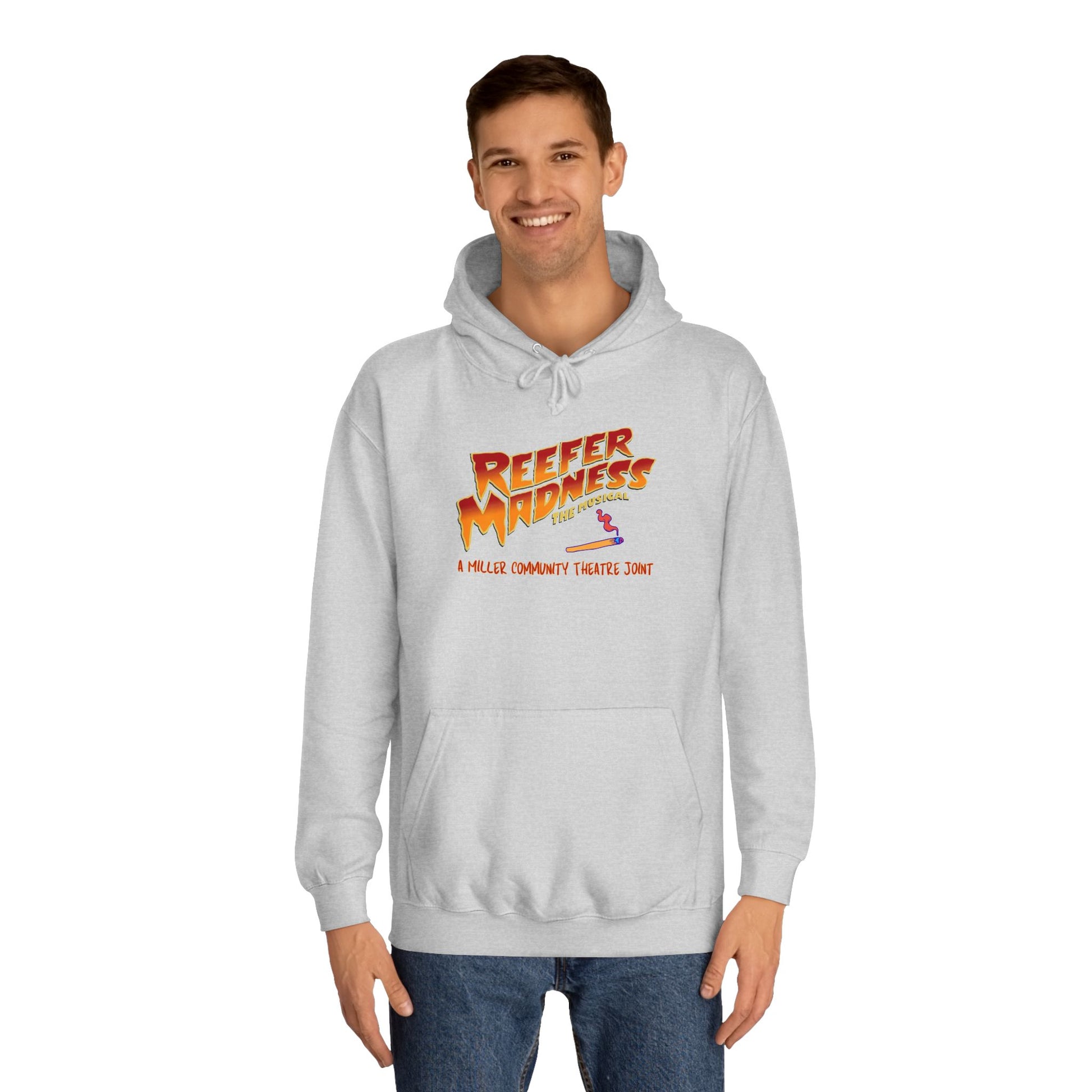 Introducing the "Reefer Madness - A Miller Community Theatre Joint" hoodie by Printify—a green hoodie with "Reefer Madness The Musical" displayed in bold, colorful font. Beneath it, the phrase "A very scary trip!" is featured. This hoodie is ideal for fans of the Miller Community Theatre production and comes with a front pocket and a drawstring hood.