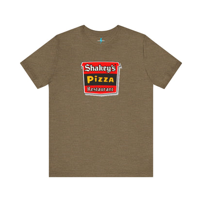 A black Shakey's Pizza - 1980s Retro Logo - Unisex T-Shirt by Printify hangs against a white background. The shirt features a colorful graphic with the text "Shakey's Pizza Restaurant" in white, yellow, and black lettering on a red background, resembling vintage pizza joints signage. This retro tee brings nostalgic vibes of classic pizzerias.