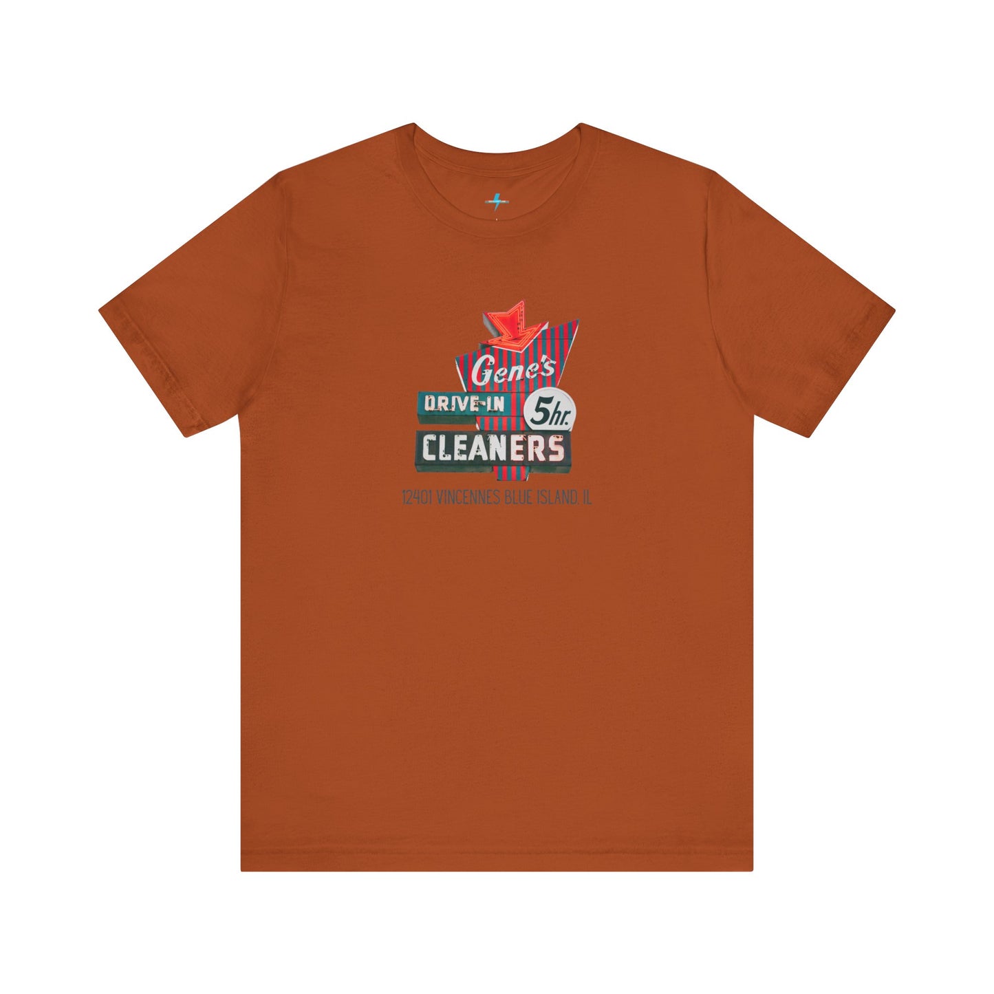 A unisex Jersey short sleeve tee from Printify featuring a light grey color with a retro-style graphic in the center. The design showcases text that reads "Gene's Drive In Cleaners, 5th," along with the address "12401 Vincennes Blue Island IL" in a blend of vintage fonts and colors, evoking the classic Chicago Fire-era vintage sign aesthetic.