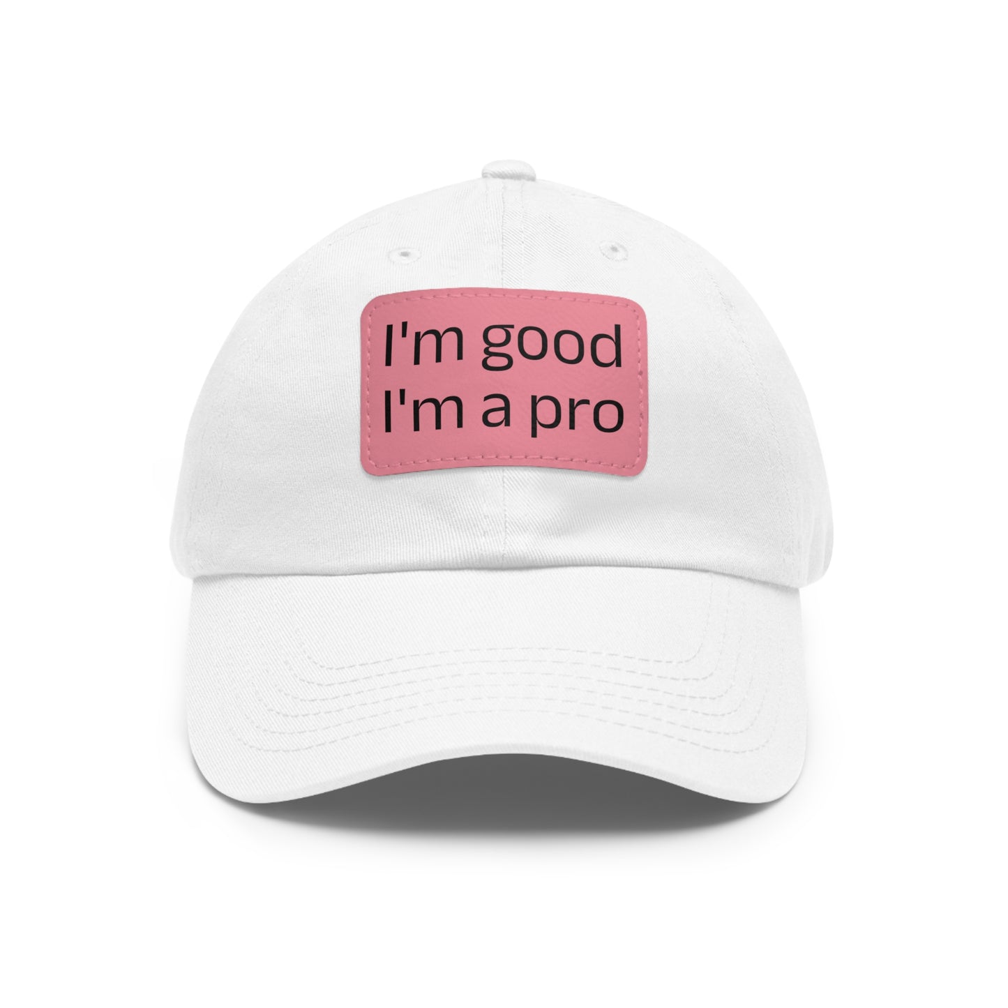 The Printify Dad Hat with Leather Patch (Rectangle) is a black, six-panel low-profile baseball cap made from bio-washed chino twill. This personalized Dad hat features a curved brim, visible stitching details, and a rectangular leather patch on the front that reads "I'm good I'm a pro" in grey text.