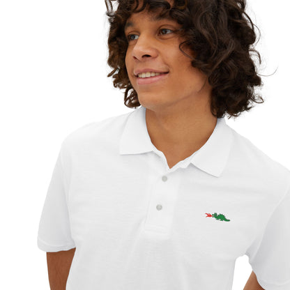 A person with curly hair wearing a navy blue Printify Braggin' Dragon - 1980s Sears Men's Piqué Polo, featuring a small embroidered dragon logo on the left chest, smiles against a plain white background.