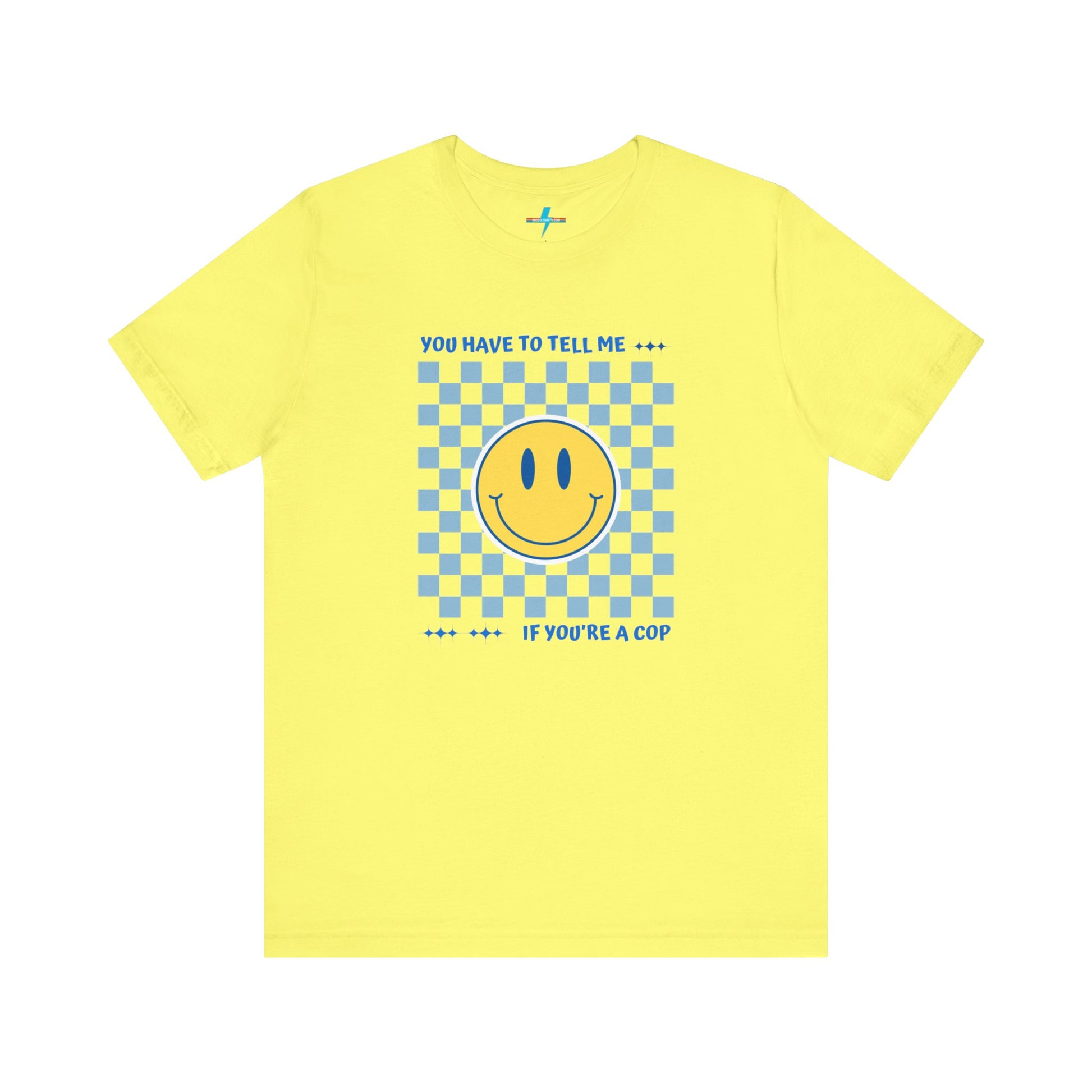 A light yellow unisex jersey short sleeve tee from Printify featuring a blue and yellow checkerboard pattern with a large yellow smiley face in the center. The shirt displays blue text above and below the pattern that reads, "You have to tell me if you're a cop." It's made from 100% Airlume combed and ring-spun cotton.