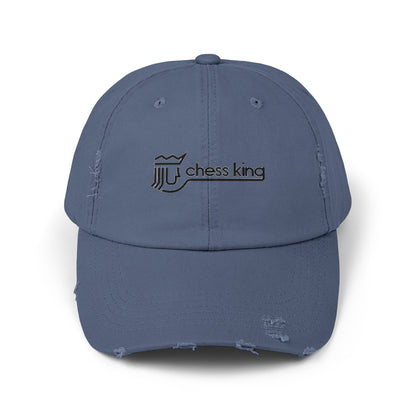 The 1980s Chess King Clothing Store Logo - Unisex Distressed Cap by Printify is a beige baseball cap made from 100% cotton twill. It features intentional distress details and a logo with a crown and rook piece, along with the text "chess king" embroidered on the front, making it a stylish choice for custom caps enthusiasts.