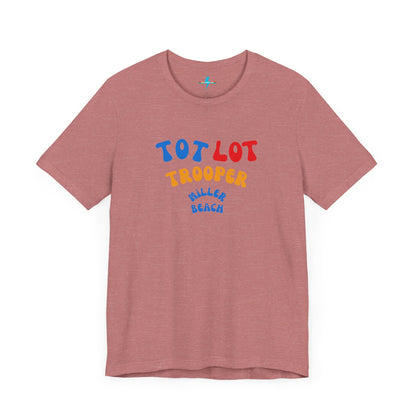 A green unisex jersey short sleeve tee from Printify, featuring colorful text on the front that reads "TOT LOT TROOPER MILLER BEACH" in blue, red, yellow, and orange letters. The shirt is displayed against a plain white background.