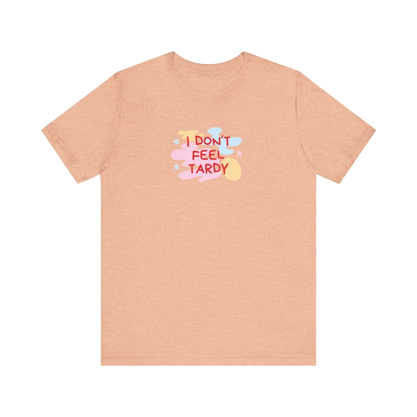 The "I Don't Feel Tardy - 1980s Retro - Unisex Jersey Short Sleeve Tee" from Printify is a light pink jersey shirt that features the bold, colorful text "I DON'T FEEL TARDY" prominently at its center. This design exudes retro vibes with small star shapes and abstract splashes of blue, yellow, and pink, laid flat against a plain background to channel pure Van Halen T-shirt energy.