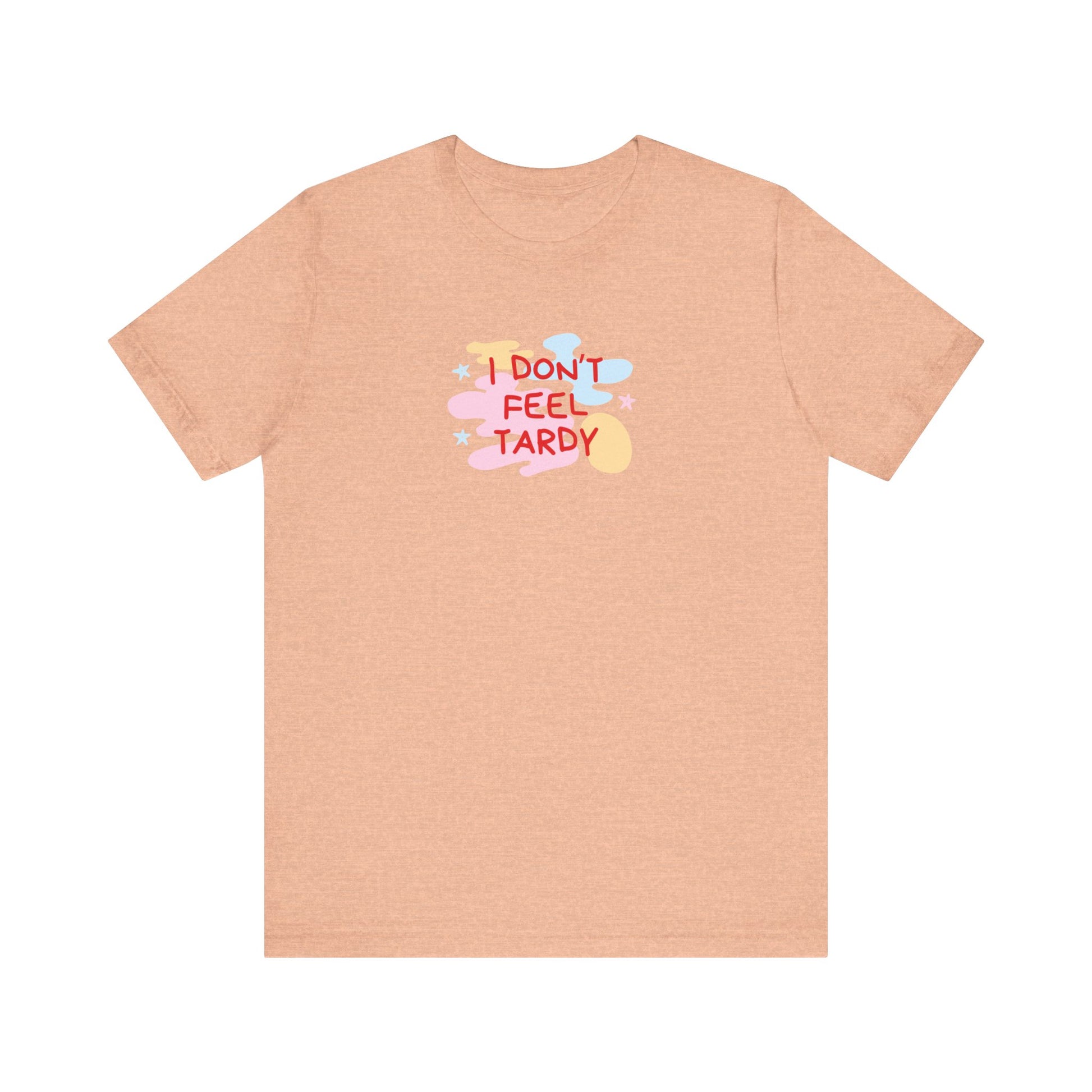 The "I Don't Feel Tardy - 1980s Retro - Unisex Jersey Short Sleeve Tee" from Printify is a light pink jersey shirt that features the bold, colorful text "I DON'T FEEL TARDY" prominently at its center. This design exudes retro vibes with small star shapes and abstract splashes of blue, yellow, and pink, laid flat against a plain background to channel pure Van Halen T-shirt energy.