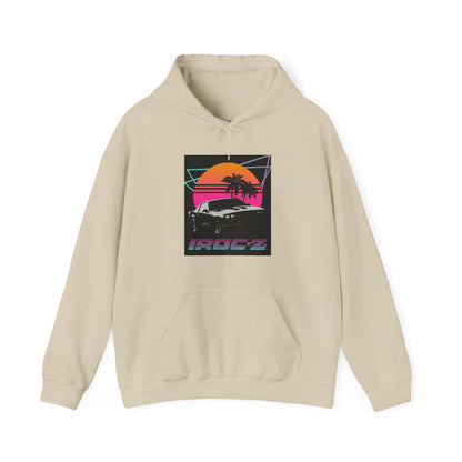 Introducing the Chevrolet IRoc Z28 - 1980s Retro Hoodie by Printify: This vibrant pink hoodie showcases a striking retro design on the front, featuring a classic American muscle car set against an orange and red sunset with palm trees, intersected by geometric shapes. The text "IROCZ" is prominently displayed below the image. Offering a relaxed fit and equipped with a front pocket, this hoodie perfectly captures the essence of 1980s style.