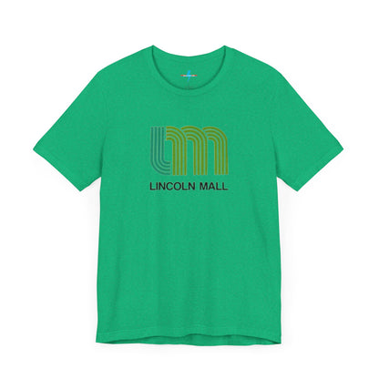 A light green unisex jersey short sleeve tee by Printify features "LINCOLN MALL" written under a retro-styled green and blue curved line design, celebrating the 70s and 80s shopping era in Lincoln Mall Matteson.