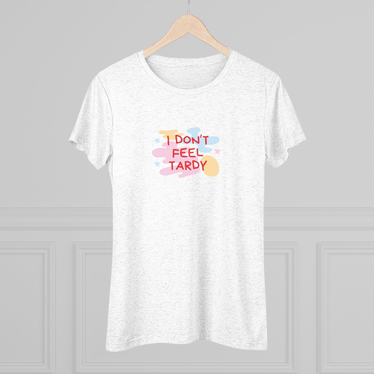 A light gray, short-sleeved Women's Triblend Tee from Printify with the playful phrase "I DON'T FEEL TARDY" printed in colorful letters on the front. The text is surrounded by abstract pastel shapes, giving it retro vibes and a vintage look reminiscent of a Van Halen T-shirt.