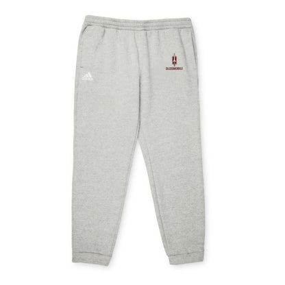 Gray Printify adidas fleece joggers with elastic waistband and cuffs, featuring the iconic Adidas logo on the upper left thigh and an "Oldsmobile - 1970s Logo" design on the right. Made with recycled polyester, they support the Better Cotton Initiative for a more sustainable future.