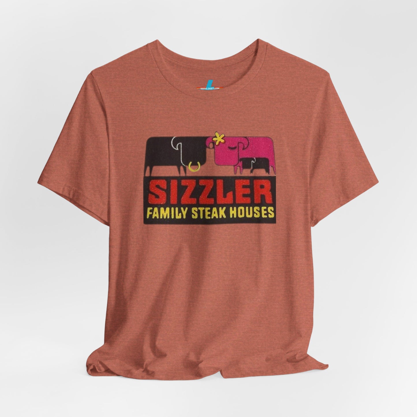 The "Sizzler Family Steakhouses - Retro 1981 Logo - Unisex Jersey Short Sleeve Tee" by Printify is a gray t-shirt showcasing a retro-style graphic with two black and pink cows, a cactus, and the text "Sizzler Family Steak Houses" in vibrant red and yellow. Ideal for any retro enthusiast, this design evokes nostalgia reminiscent of vintage restaurant logos from 1981.