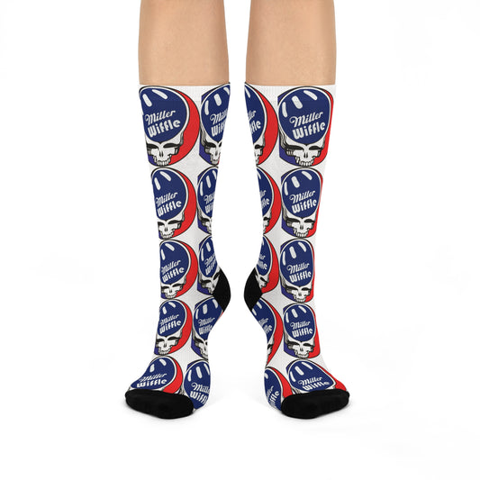 A person is wearing cushioned crew socks from Printify, featuring a repeating red, white, and blue circular "Miller Wiffel" logo atop a wiffle ball icon. These knee-high socks have black toes and heels against a plain white background, ensuring comfort with every step.