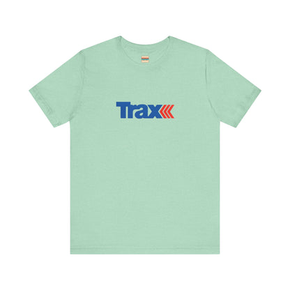 A gray unisex jersey short sleeve tee from Printify, inspired by retro 1980s Kmart style. The "Trax" logo is printed in blue letters, followed by three red arrows pointing to the right. This classic Trax Brand T-shirt is laid flat against a white background, capturing nostalgic fashion vibes.