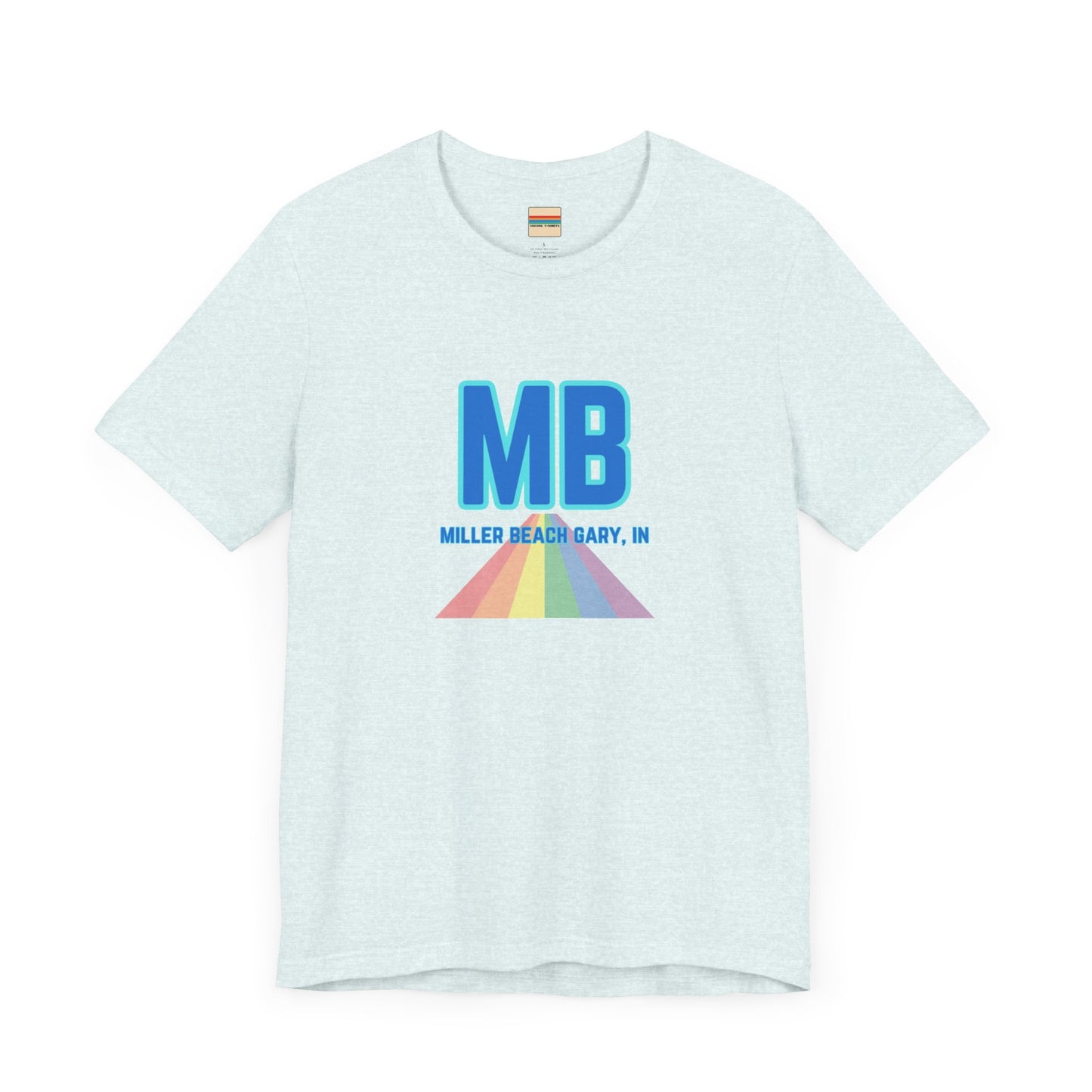 The Miller Beach Pride - Unisex Jersey Short Sleeve Tee by Printify is a white shirt made from 100% Airlume combed cotton. It showcases a design with large, bold blue letters "MB" at the top. Beneath it, the text "MILLER BEACH GARY, IN" is written in blue. A colorful, triangular rainbow graphic extends downward from the text, symbolizing Miller Beach pride.