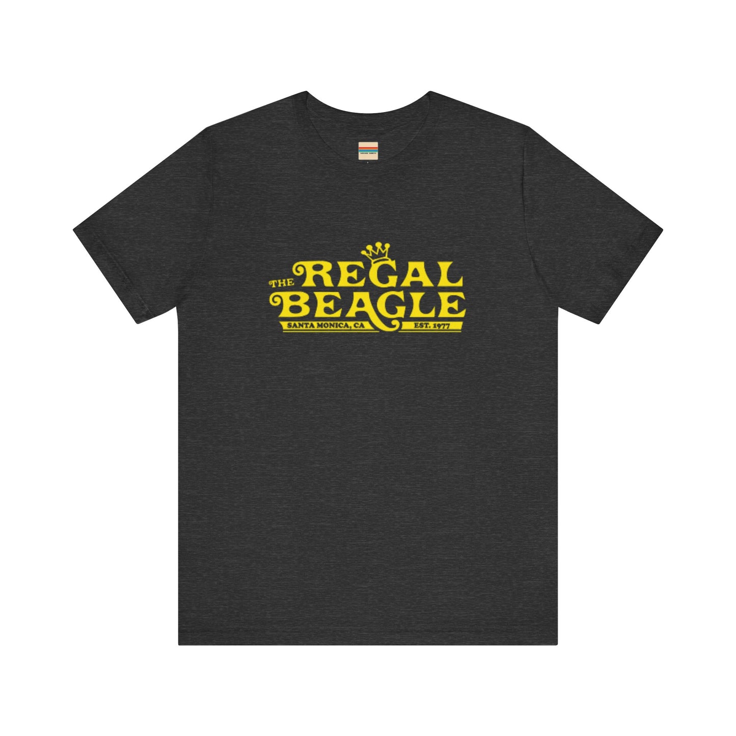 The Printify Regal Beagle - Three's Company Unisex Jersey Short Sleeve Tee, in black, showcases "The Regal Beagle, Santa Monica, CA, Est. 1977" text in a yellow vintage-style font. Crafted from 100% Airlume combed cotton for superior comfort.