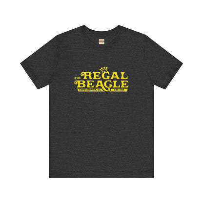 The Printify Regal Beagle - Three's Company Unisex Jersey Short Sleeve Tee, in black, showcases "The Regal Beagle, Santa Monica, CA, Est. 1977" text in a yellow vintage-style font. Crafted from 100% Airlume combed cotton for superior comfort.