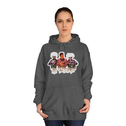 The David S Pumpkins - Any Questions? - Halloween Unisex College Hoodie by Printify is a brown sweatshirt showcasing an illustration of three people. The central figure has red hair, sports a colorful ensemble, and emanates a Halloween vibe, with two flanking figures who have white hair and wear dark attire. Beneath the trio is the phrase "Any Questions?