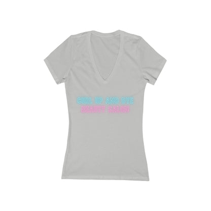 A Printify Blues Brothers Curl Up and Dye Women's Jersey Short Sleeve Deep V-Neck Tee in light gray is shown against a white background. This comfortable wardrobe essential showcases "CURL UP AND DYE" in light blue and "BEAUTY SALON" in light pink printed across the chest, featuring a modern feminine fit.