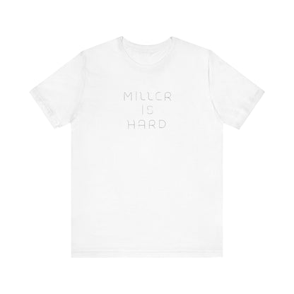 The Miller is Hard - White Letters - Unisex Jersey Short Sleeve Tee by Printify features a rust-colored design with "MILLER IS HARD" printed in bold, white capitals on the front. Below, "GARY, IN." is added in smaller font. This simple yet striking shirt evokes the spirit of Miller Beach with no additional graphics or patterns.