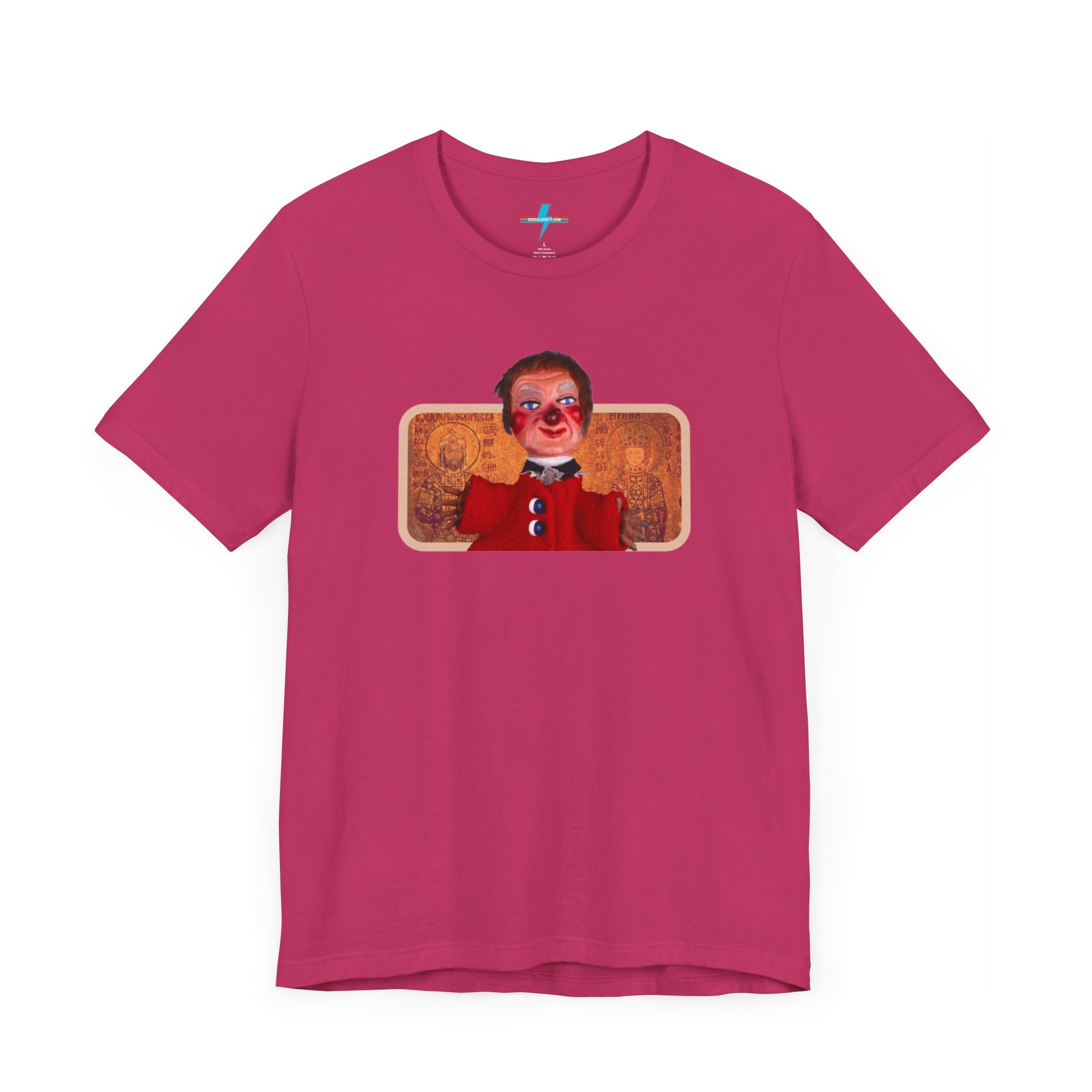 The rust-colored Printify Lady Elaine - Mr. Rogers Unisex Jersey Short Sleeve Tee features a detailed image of the Lady Elaine puppet, dressed in a red outfit with a painted face, set against an intricate artistic backdrop. The centrally positioned puppet and vivid colors create a striking contrast against the muted tone of the shirt, evoking nostalgic memories of Mr. Rogers' Neighborhood.