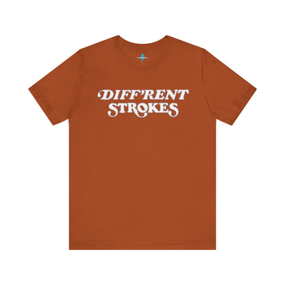 A burnt orange "Diff’Rent Strokes - Retro 1980s" unisex jersey short sleeve tee by Printify, featuring the phrase "DIFF'RENT STROKES" in bold, white cursive letters across the chest. The plain white backdrop perfectly showcases this nostalgic TV apparel.