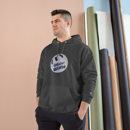 A navy blue Printify Miller Beach Wiffle Ball OG Logo - Sweatshirt, featuring a white wiffle ball graphic on the chest with "Miller Wiffle" in blue beneath it. Made from recycled polyester, this hoodie includes a front pocket, drawstrings, and the Champion logo on the left sleeve. It also offers Double Dry® technology for added comfort.