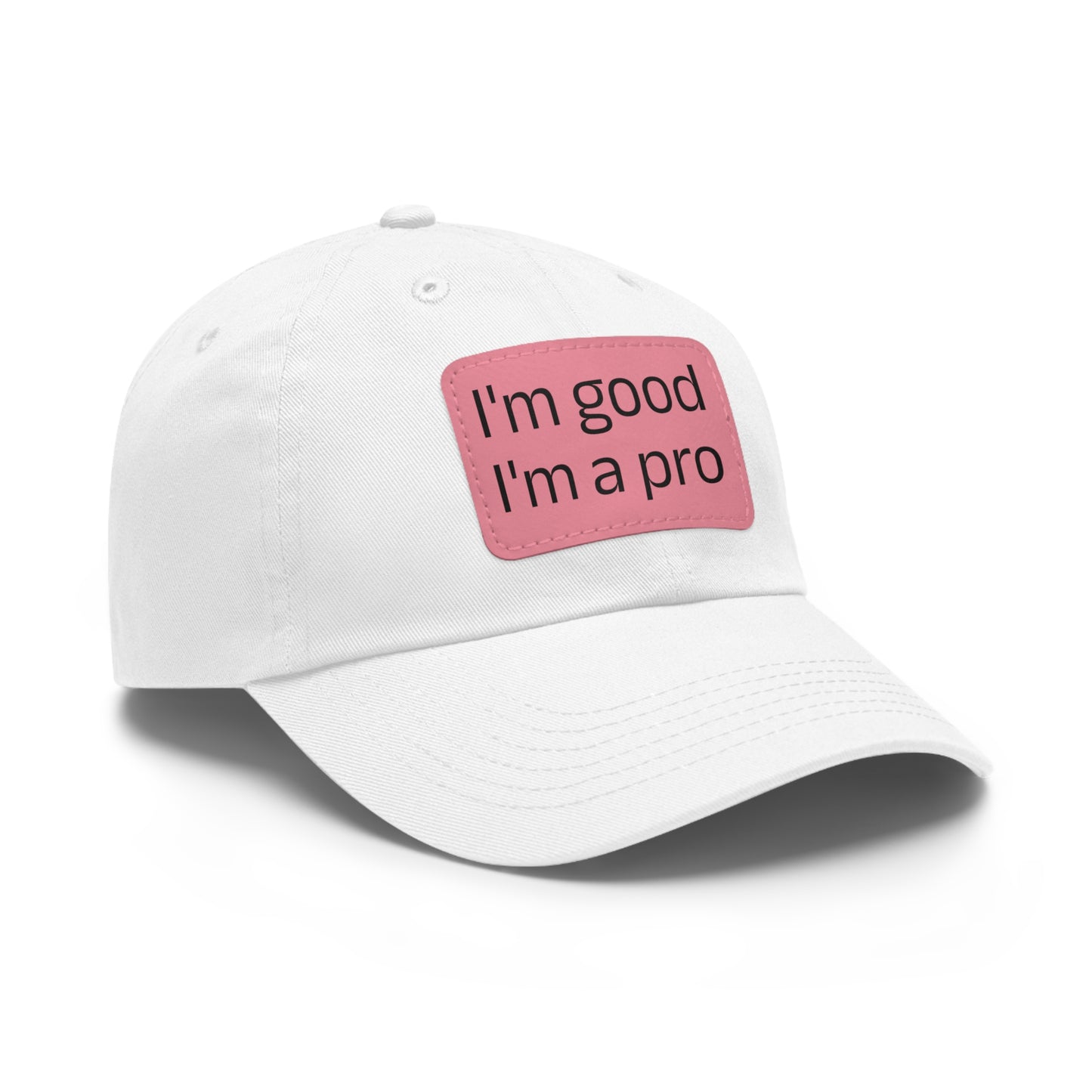 The Printify Dad Hat with Leather Patch (Rectangle) is a black, six-panel low-profile baseball cap made from bio-washed chino twill. This personalized Dad hat features a curved brim, visible stitching details, and a rectangular leather patch on the front that reads "I'm good I'm a pro" in grey text.