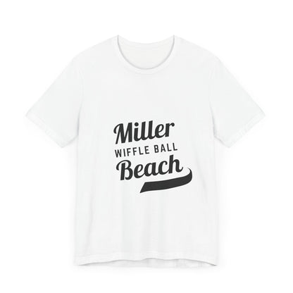 A light blue, soft cotton t-shirt with the text "Miller Beach Wiffel Ball" printed in black on the front. The design features a stylized, curved underline beneath the word "Beach," giving the text a dynamic appearance. This unisex jersey offers a comfortable retail fit for all. Product Name: Miller Beach Wiffel Ball - Unisex Jersey Short Sleeve Tee Retro Logo by Printify.