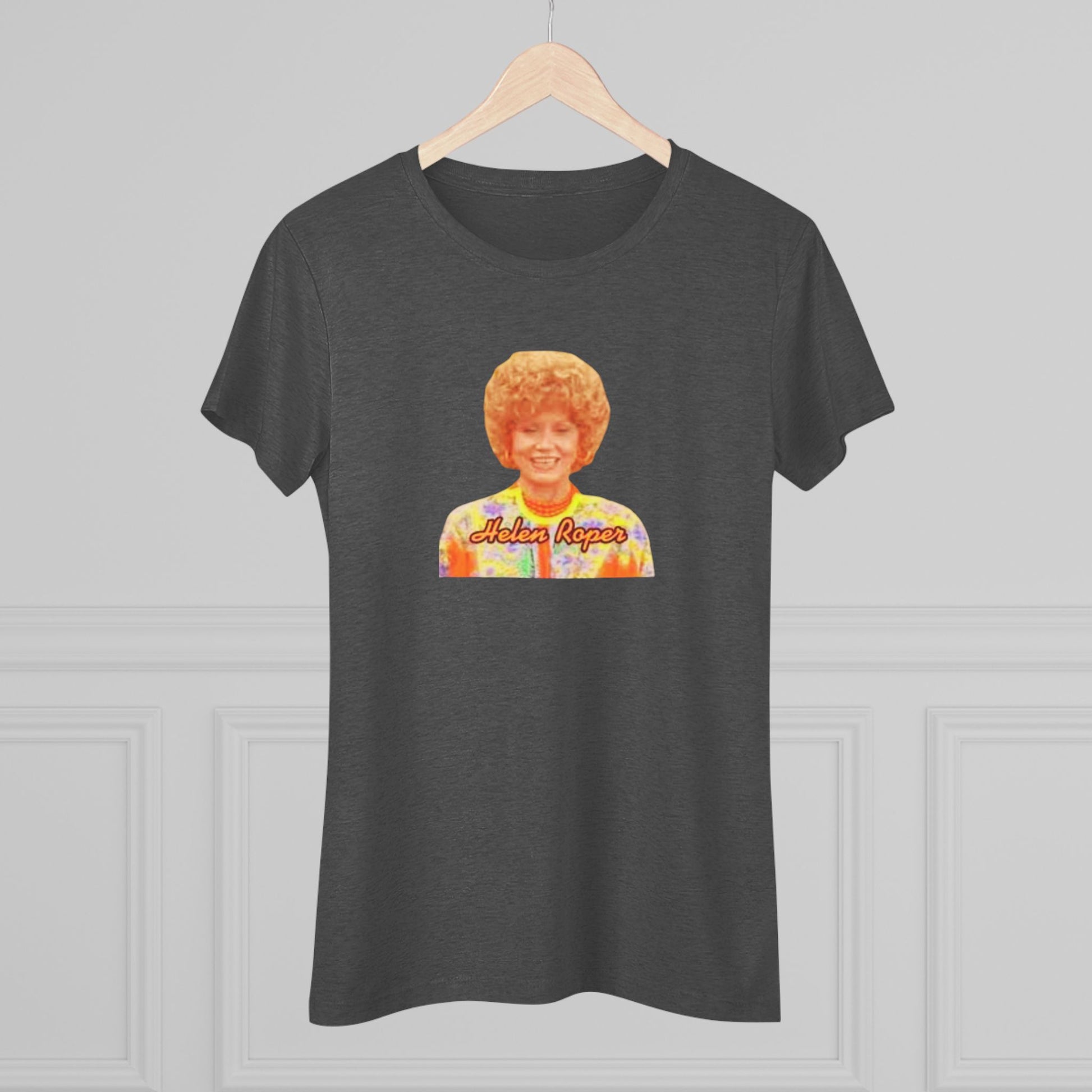 A Women's Triblend Tee by Printify, titled "Helen Roper - Three's Company," features a red design with an illustration of a smiling person with curly hair and colorful clothing. Below the illustration, the text "Helen Roper" is written in a bold, retro font, capturing the essence of vintage TV humor.