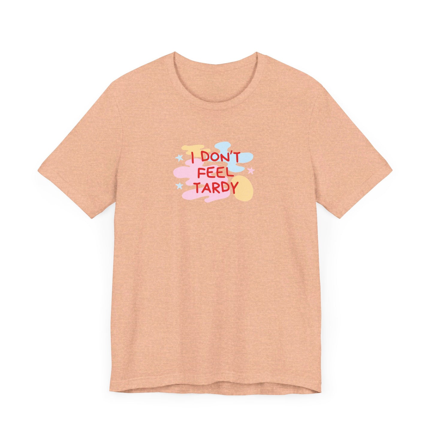 The "I Don't Feel Tardy - 1980s Retro - Unisex Jersey Short Sleeve Tee" from Printify is a light pink jersey shirt that features the bold, colorful text "I DON'T FEEL TARDY" prominently at its center. This design exudes retro vibes with small star shapes and abstract splashes of blue, yellow, and pink, laid flat against a plain background to channel pure Van Halen T-shirt energy.