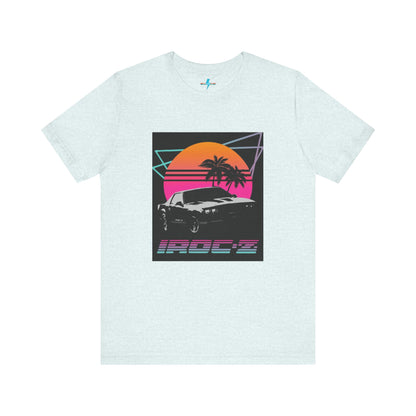 A Chevrolet Camaro iRoc Z Z28 T-Shirt 1980's by Printify, featuring a retro design with a black car, palm trees, and a sun setting in the background. The design includes geometric lines in neon colors and the text "IROC-Z" at the bottom, perfect for fans of the 1980s Chevy Camaro.